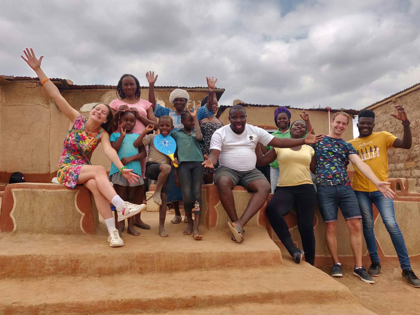 Travellers and community hosts celebrating together at a village homestead