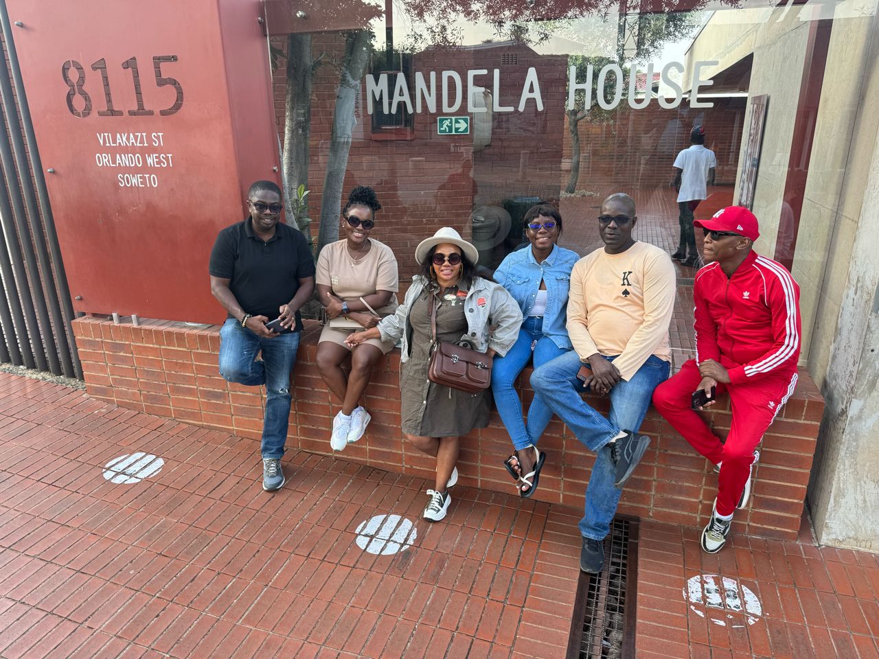 Injula Tours guests seated outside Mandela House on Vilakazi Street, Soweto