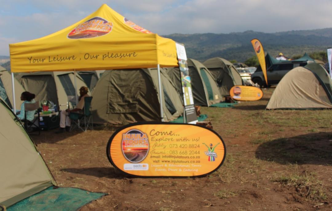 Injula Tours branded gazebo and tents pitched at a mountain camp site